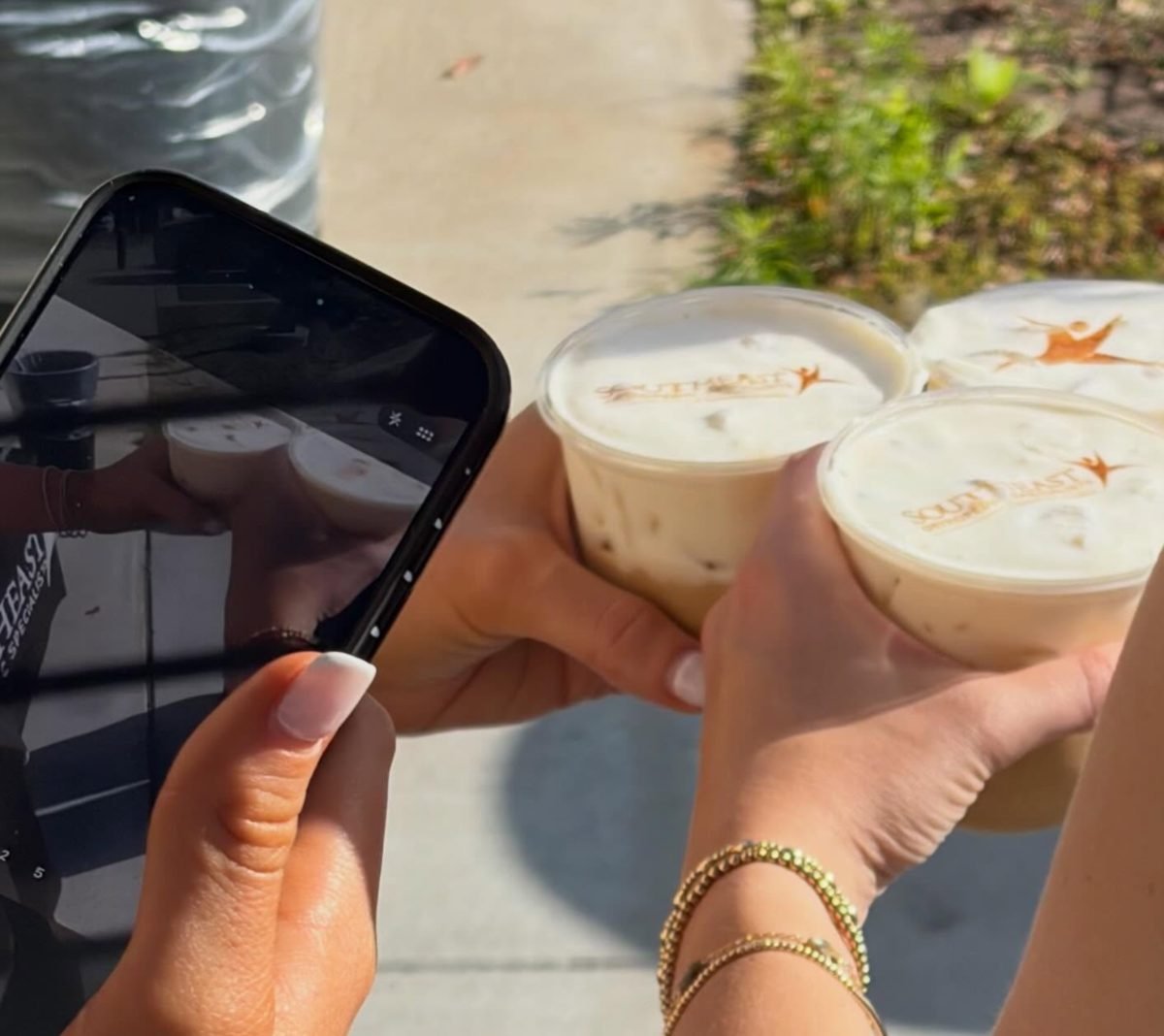 Guests holding iced lattes with a company logo printed on the cold foam